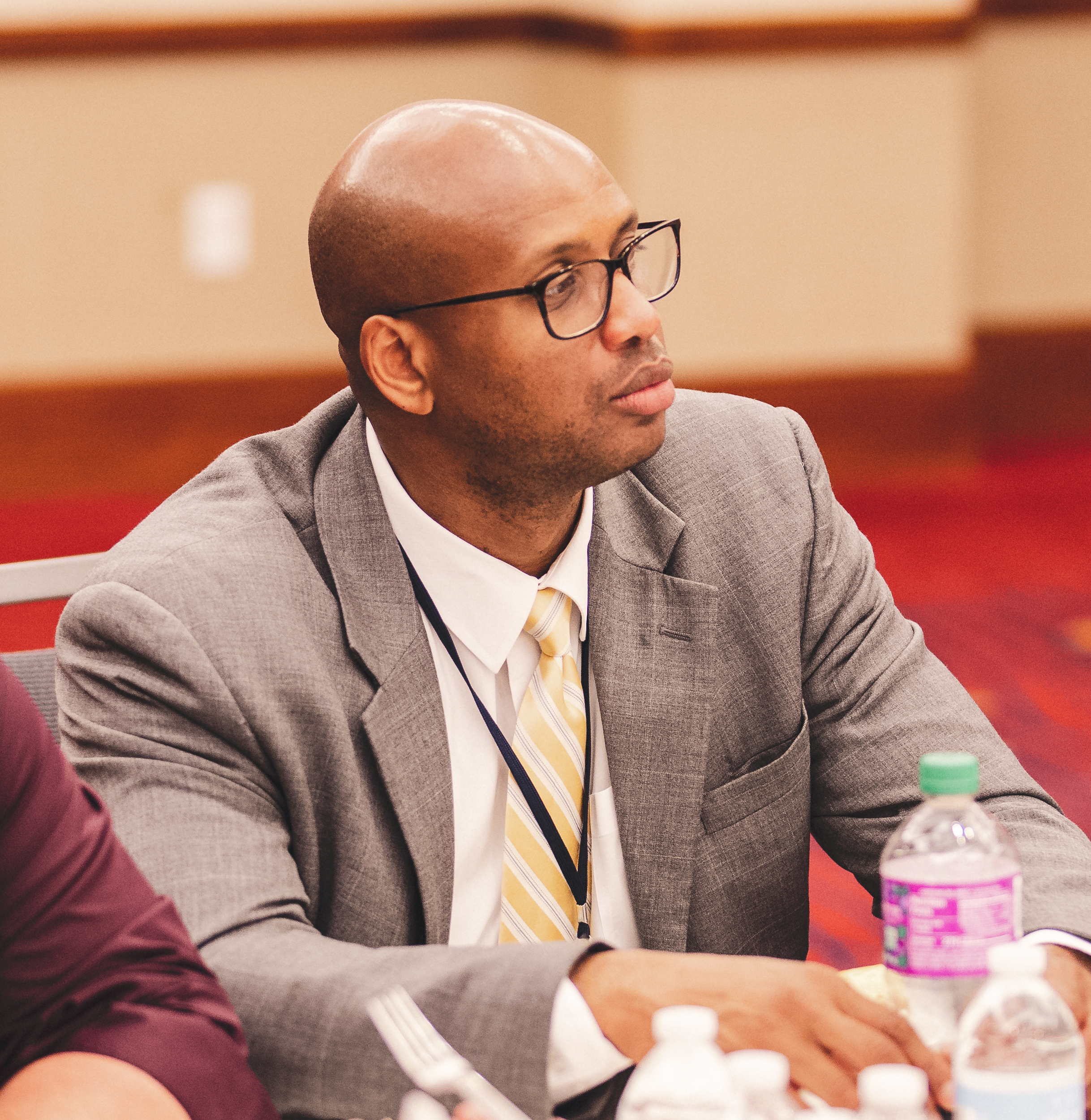 A participant in a gray suit and striped tie listens attentively during a Leadership Institute training workshop.